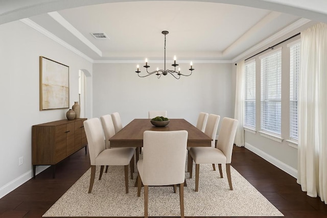 3501 Venezia Vw, Leander, TX 78641 - dining space featuring a chandelier, dark wood finished floors, arched walkways, a raised ceiling, and ornamental molding