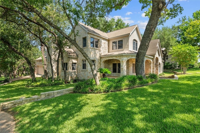2928 Chatelaine Dr, Austin, TX 78746 - view of front of home featuring stone siding, a front lawn, and an attached garage