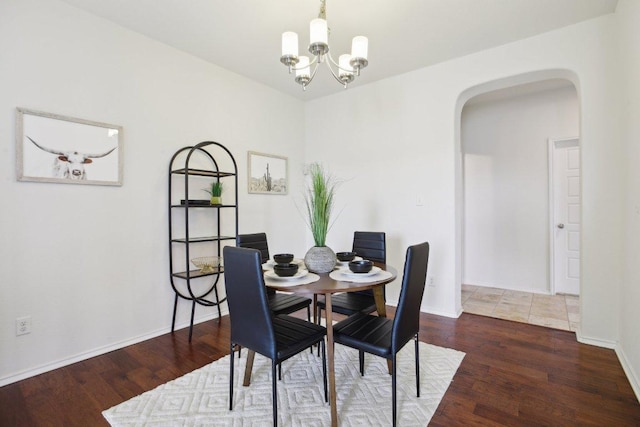 1318 Autumn Sage Way, Pflugerville, TX 78660 - dining room with arched walkways, wood finished floors, a chandelier, and baseboards