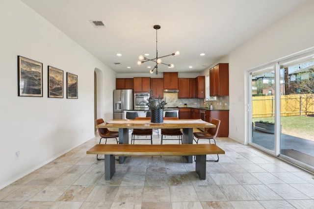 1318 Autumn Sage Way, Pflugerville, TX 78660 - dining area with arched walkways, a chandelier, recessed lighting, and baseboards