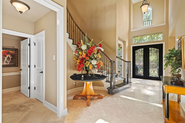 2116 University Club Dr, Austin, TX 78732 - foyer entrance featuring stairway, french doors, tile patterned flooring, a high ceiling, and baseboards