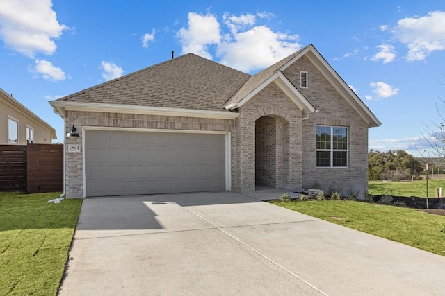 7804 Alouette Dr, Austin, TX 78738 - view of front of home with driveway, a garage, brick siding, and a shingled roof