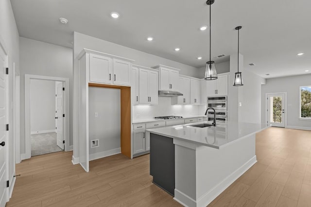 7804 Alouette Dr, Austin, TX 78738 - kitchen with a sink, gas stovetop, light wood-style flooring, white cabinetry, and recessed lighting
