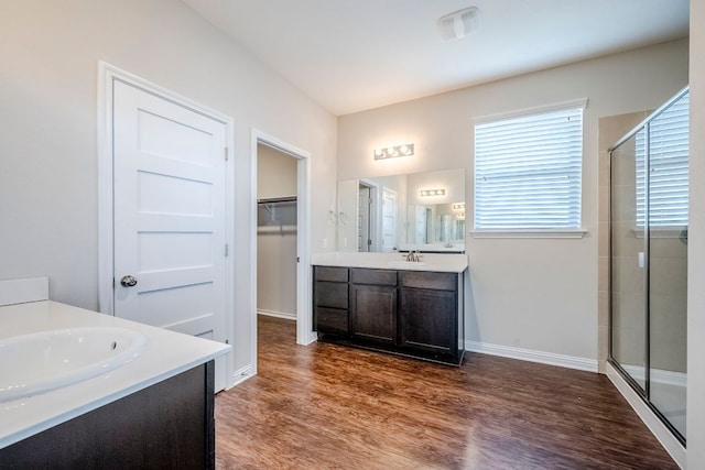8017 Turnberry Ln, Austin, TX 78744 - full bath with a stall shower, two vanities, wood finished floors, a spacious closet, and baseboards