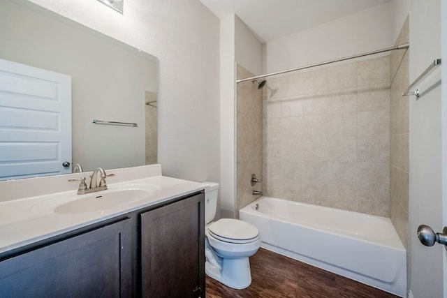 8017 Turnberry Ln, Austin, TX 78744 - bathroom with toilet, vanity, washtub / shower combination, and wood finished floors
