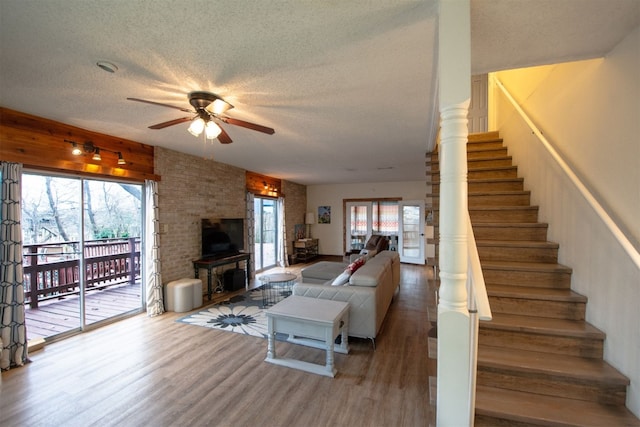 1683 Kuehler Ave, New Braunfels, TX 78130 - living room with ceiling fan, a textured ceiling, wood finished floors, a wood stove, and stairs