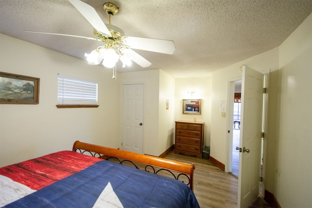 1683 Kuehler Ave, New Braunfels, TX 78130 - bedroom featuring wood finished floors, a textured ceiling, multiple windows, and ceiling fan