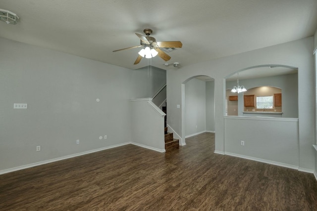 1225 Cardigan St, Cedar Park, TX 78613 - spare room featuring dark wood-style floors, arched walkways, a ceiling fan, baseboards, and stairway