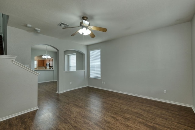 1225 Cardigan St, Cedar Park, TX 78613 - empty room featuring ceiling fan, a chandelier, dark wood-style floors, arched walkways, and baseboards