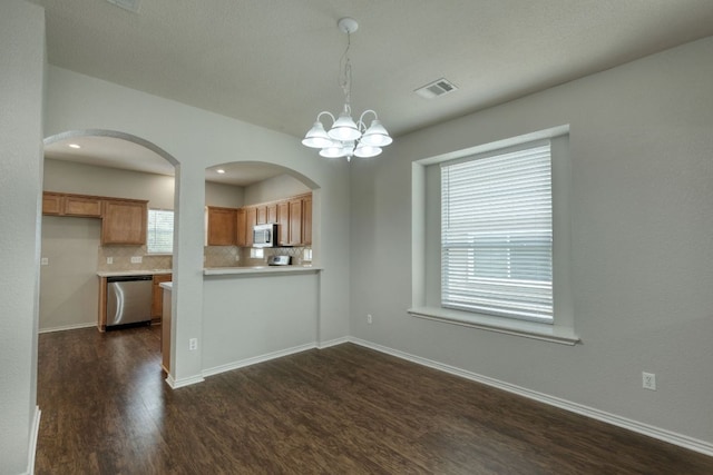 1225 Cardigan St, Cedar Park, TX 78613 - kitchen with appliances with stainless steel finishes, dark wood-type flooring, a chandelier, tasteful backsplash, and healthy amount of natural light