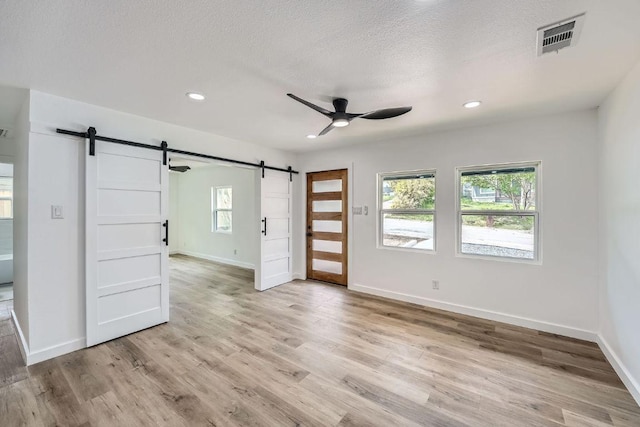 1601 N Redondo Dr, Austin, TX 78721 - unfurnished room with a barn door, ceiling fan, healthy amount of natural light, recessed lighting, and a textured ceiling