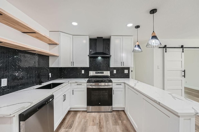 1601 N Redondo Dr, Austin, TX 78721 - kitchen featuring wall chimney range hood, stainless steel appliances, a sink, open shelves, and a peninsula