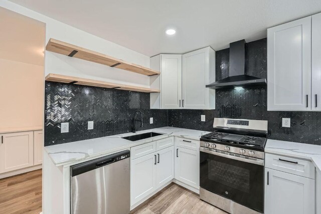 1601 N Redondo Dr, Austin, TX 78721 - kitchen with stainless steel appliances, wall chimney range hood, a sink, open shelves, and light wood-style flooring