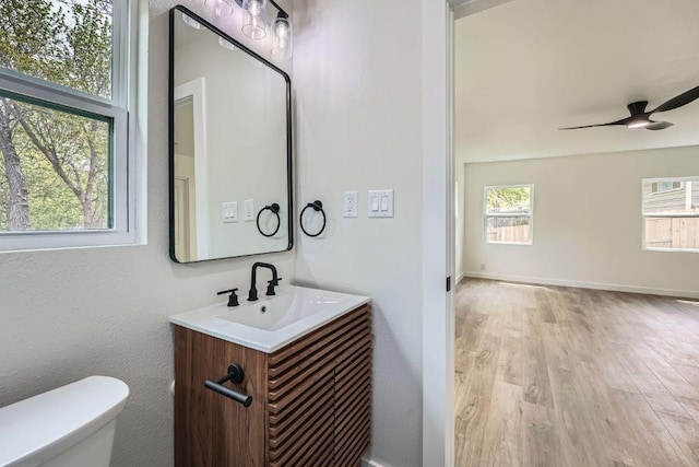 1601 N Redondo Dr, Austin, TX 78721 - half bathroom with vanity, toilet, wood finished floors, ceiling fan, and baseboards