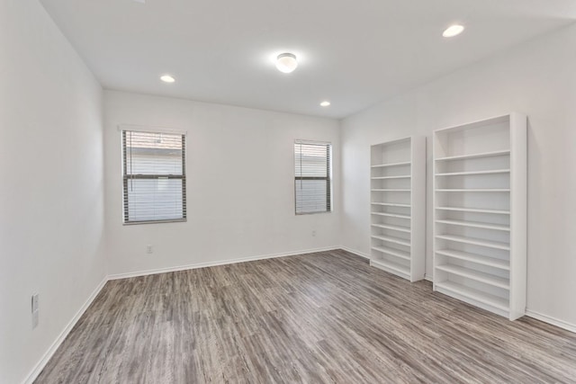 2308 Ringstaff Rd, Leander, TX 78641 - unfurnished bedroom with multiple windows, wood finished floors, recessed lighting, and baseboards