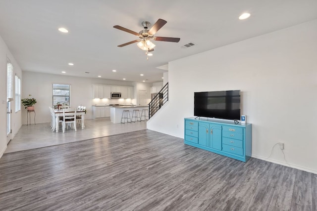 2308 Ringstaff Rd, Leander, TX 78641 - unfurnished living room with light wood-type flooring, stairs, a ceiling fan, recessed lighting, and baseboards