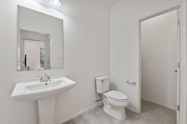 2308 Ringstaff Rd, Leander, TX 78641 - bathroom featuring toilet, tile patterned flooring, baseboards, and a sink