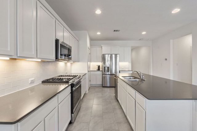 2308 Ringstaff Rd, Leander, TX 78641 - kitchen featuring stainless steel appliances, a sink, dark countertops, a kitchen island with sink, and recessed lighting