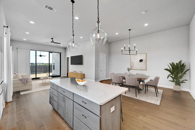 7200 Cordoba Dr, Austin, TX 78724 - kitchen with gray cabinetry, open floor plan, a center island, light wood finished floors, and recessed lighting