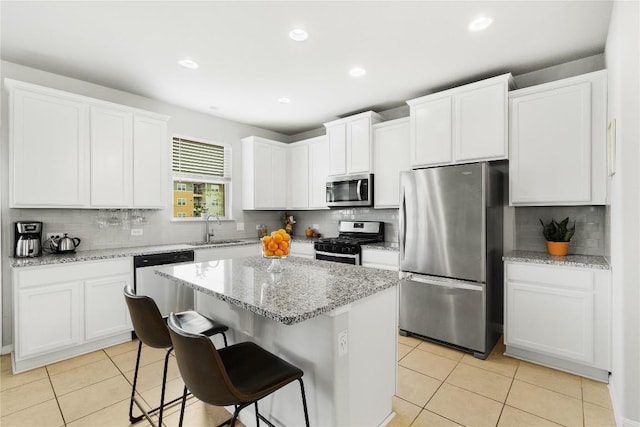 kitchen featuring appliances with stainless steel finishes, a sink, light tile patterned flooring, tasteful backsplash, and recessed lighting