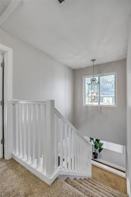 3510 Oak Springs Dr, Austin, TX 78721 - stairway with a chandelier and carpet