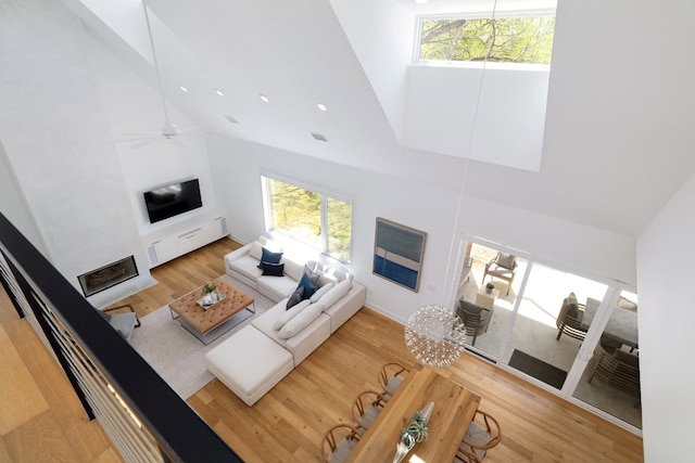 living room with visible vents, recessed lighting, wood finished floors, a ceiling fan, and high vaulted ceiling