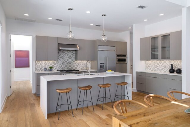 kitchen featuring built in refrigerator, a sink, modern cabinets, and gray cabinets
