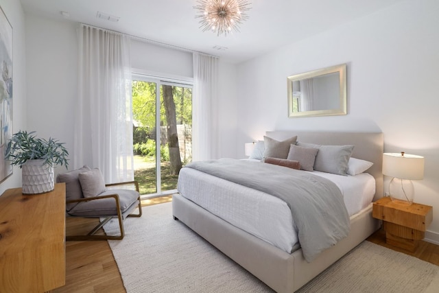 bedroom featuring visible vents, wood finished floors, and access to exterior