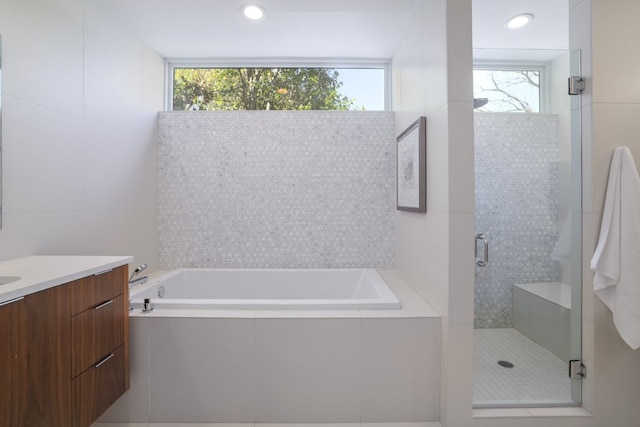 full bathroom featuring a healthy amount of sunlight, vanity, a garden tub, and a stall shower