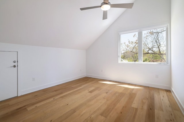 additional living space with light wood-type flooring, a ceiling fan, vaulted ceiling, and baseboards