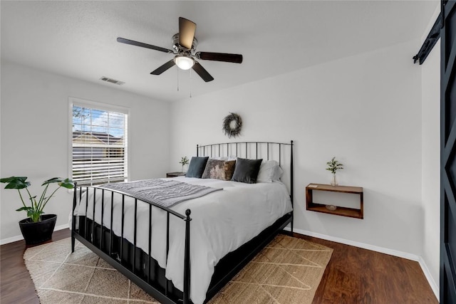 5898 River Oaks Dr, Kingsland, TX 78639 - bedroom with wood finished floors, baseboards, ceiling fan, and visible vents