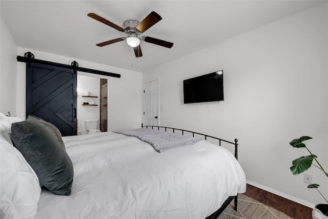 5898 River Oaks Dr, Kingsland, TX 78639 - bedroom with a ceiling fan, baseboards, a barn door, and wood finished floors