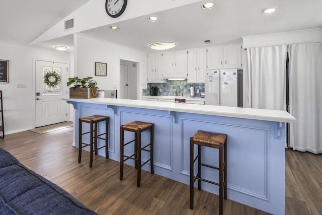 2546 Williams Lakeshore, Kingsland, TX 78639 - kitchen featuring freestanding refrigerator, dark wood-style flooring, white cabinets, light countertops, and a kitchen breakfast bar