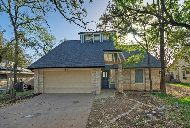 1701 Indian Camp Trl, Round Rock, TX 78681 - view of front facade with roof with shingles, stone siding, concrete driveway, and a garage