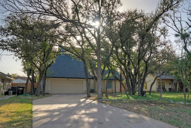 1701 Indian Camp Trl, Round Rock, TX 78681 - obstructed view of property with concrete driveway, a garage, and a shingled roof