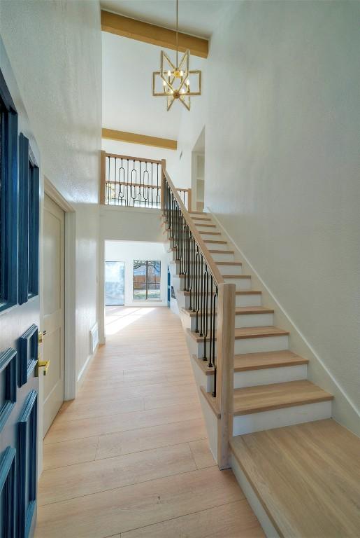 1701 Indian Camp Trl, Round Rock, TX 78681 - stairs featuring a towering ceiling, a chandelier, and wood finished floors