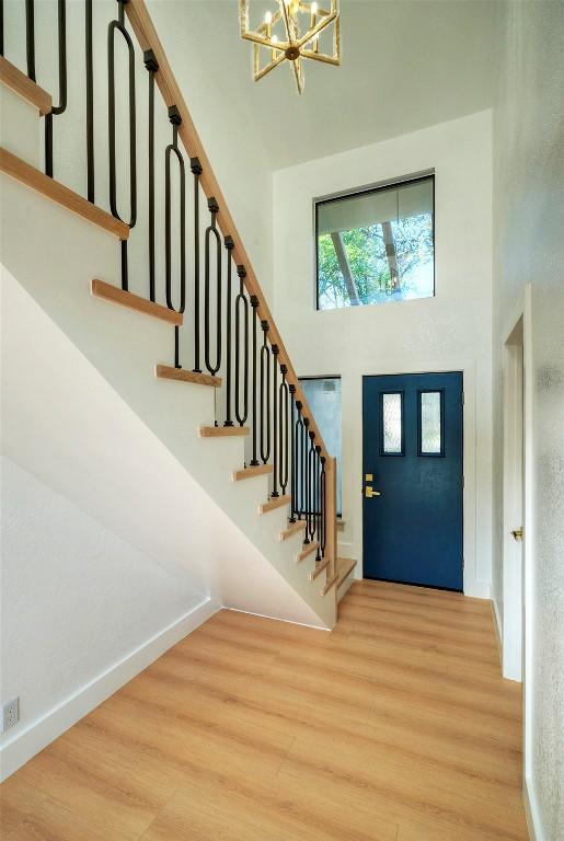 1701 Indian Camp Trl, Round Rock, TX 78681 - foyer featuring a chandelier, a towering ceiling, stairway, and wood finished floors