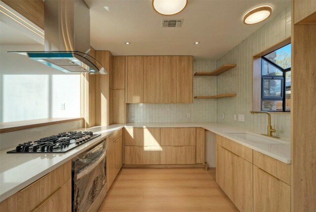 1701 Indian Camp Trl, Round Rock, TX 78681 - kitchen featuring ventilation hood, oven, stainless steel gas stovetop, modern cabinets, and light wood-style flooring