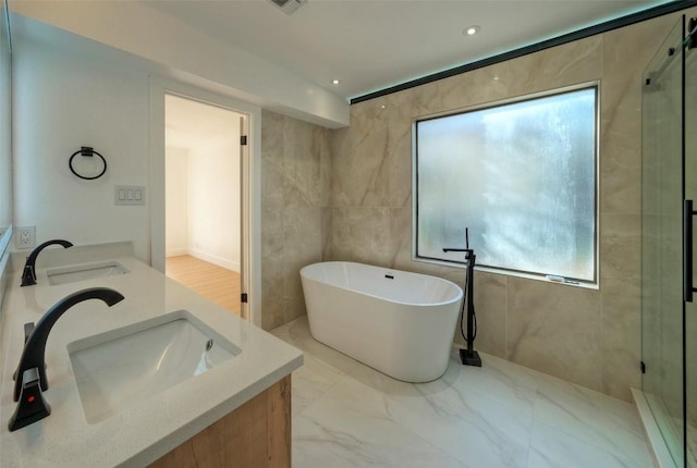 1701 Indian Camp Trl, Round Rock, TX 78681 - full bath featuring double vanity, a freestanding bath, a stall shower, marble finish flooring, and recessed lighting