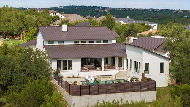 204 Ringtail Stream Dr, Lakeway, TX 78738 - rear view of house with a fenced backyard, a patio area, stucco siding, a pool with connected hot tub, and metal roof