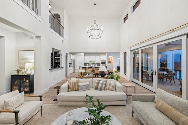 204 Ringtail Stream Dr, Lakeway, TX 78738 - living room with light wood-type flooring, a chandelier, a high ceiling, baseboards, and french doors
