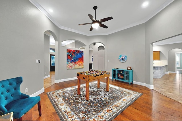 104 Standing Oak Dr, Georgetown, TX 78633 - recreation room with arched walkways, a ceiling fan, crown molding, wood finished floors, and baseboards