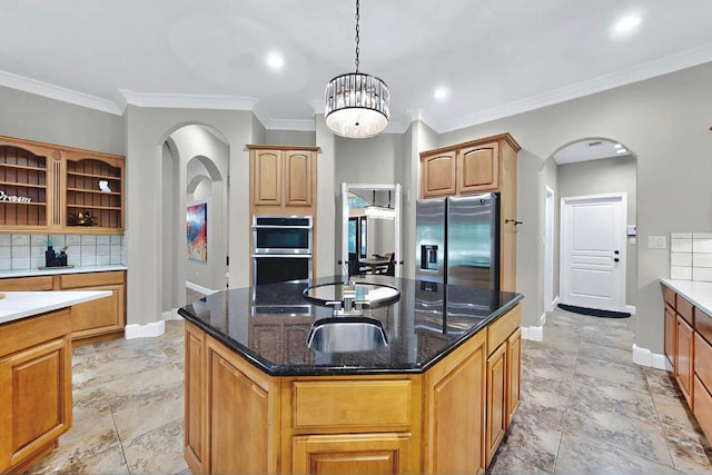 104 Standing Oak Dr, Georgetown, TX 78633 - kitchen with stainless steel appliances, baseboards, arched walkways, an island with sink, and crown molding