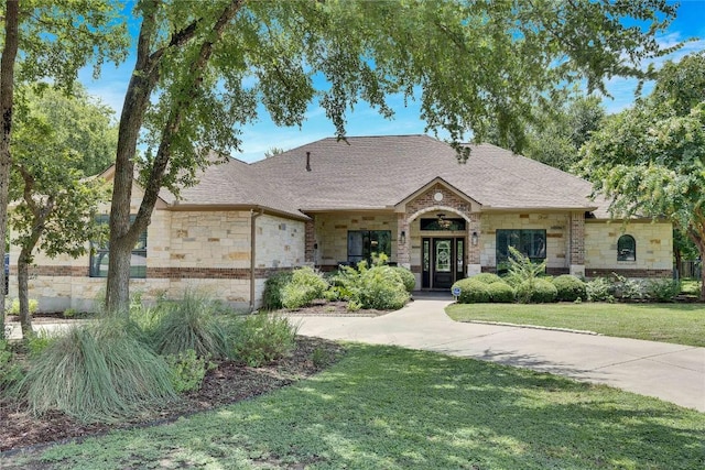 104 Standing Oak Dr, Georgetown, TX 78633 - french provincial home featuring stone siding, a front lawn, and roof with shingles