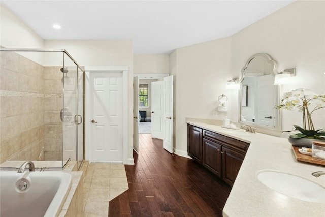 1420 Mirador, Leander, TX 78641 - full bathroom with double vanity, a shower stall, a garden tub, wood finished floors, and recessed lighting