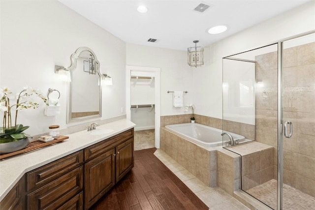 1420 Mirador, Leander, TX 78641 - bathroom featuring a garden tub, a shower stall, wood finished floors, vanity, and a walk in closet
