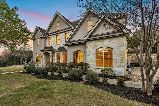 1420 Mirador, Leander, TX 78641 - view of front of home featuring stone siding, stucco siding, a lawn, and central air condition unit