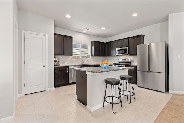 217 Timber Brook Dr, Hutto, TX 78634 - kitchen featuring stainless steel appliances, a breakfast bar area, decorative backsplash, stone counters, and recessed lighting