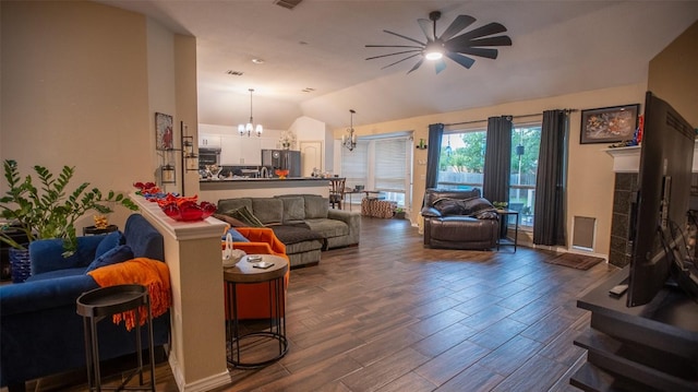 living area featuring lofted ceiling, ceiling fan with notable chandelier, dark wood-style floors, and visible vents