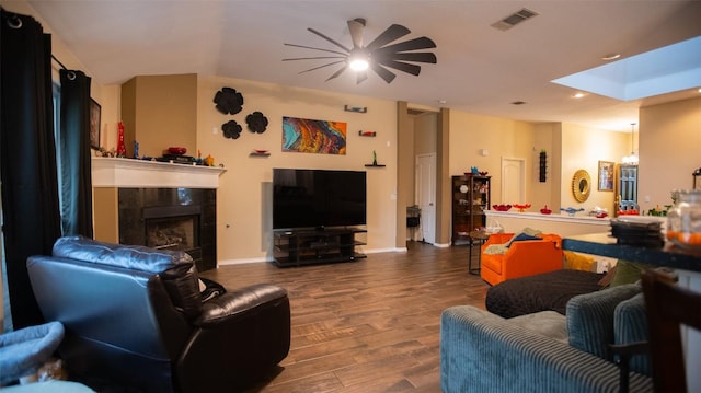 living area featuring a skylight, wood finished floors, visible vents, recessed lighting, and a fireplace